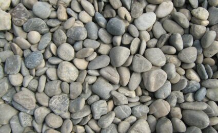 Closely packed gray and beige Danube pebbles with rounded edges and varied flattened shapes.